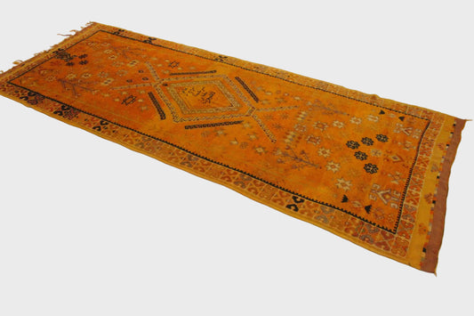 Orange rug with black geometric patterns on a white background