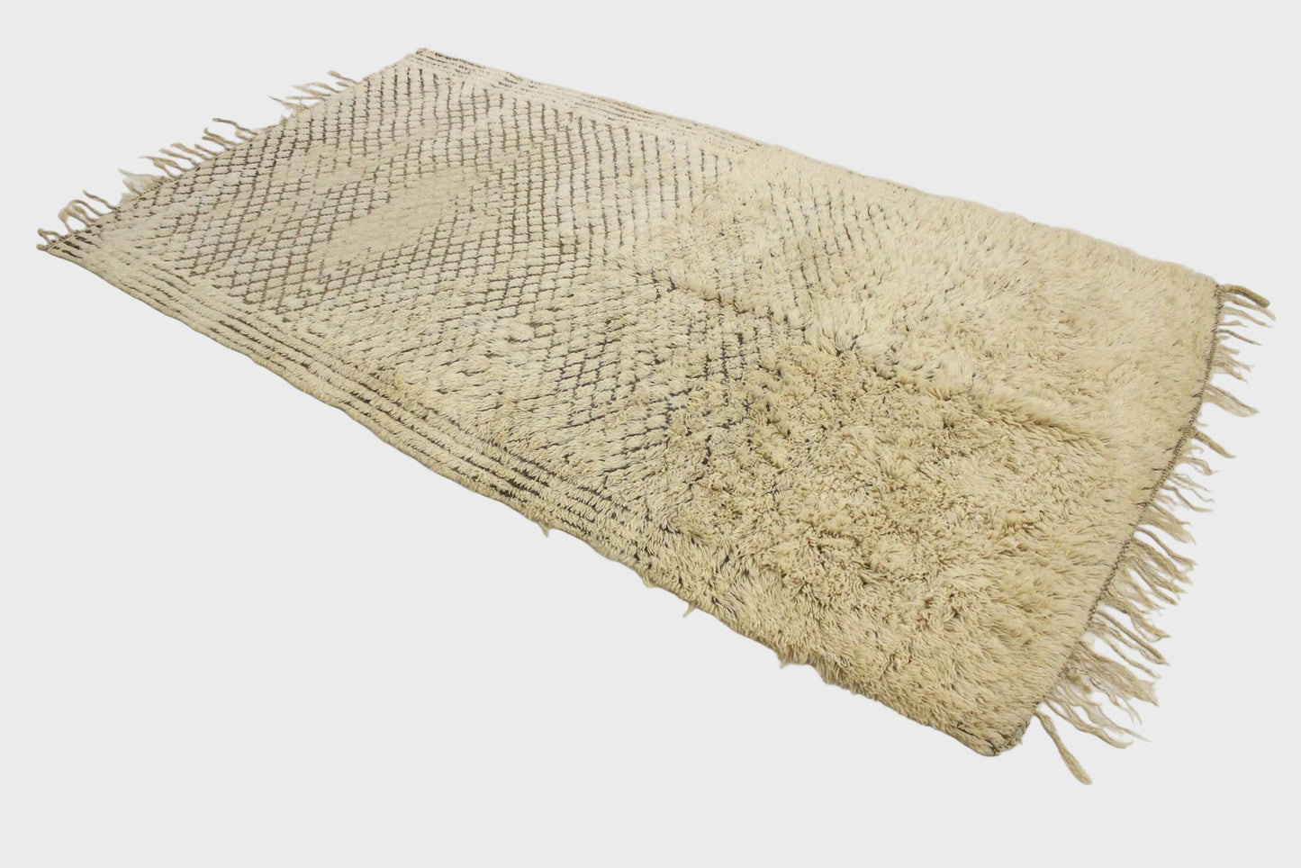 Beige woven mat with fringes on a white background