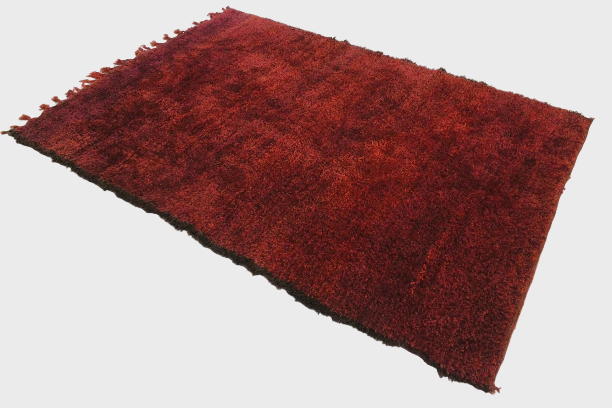 Red shaggy rug on a white floor