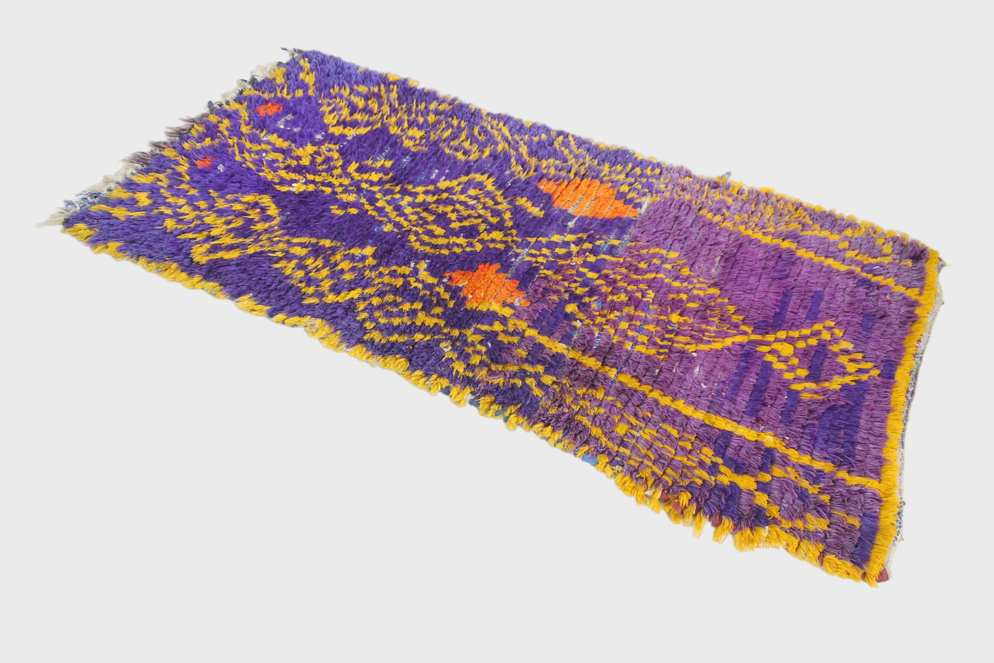 Purple and yellow woven textile on a white background
